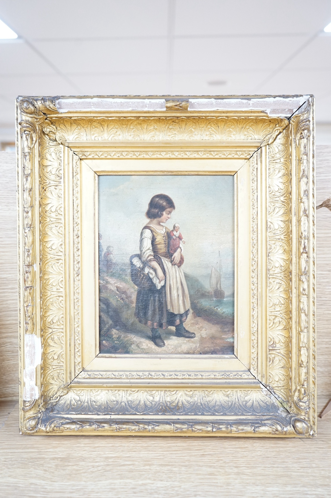 19th century, French School, oil on canvas, Girl holding a doll standing upon the seashore, 21 x 16cm, ornate gilt framed. Condition - fair, losses to the frame